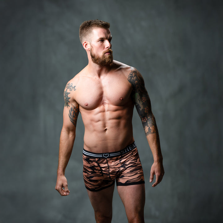 Male model in front of studio backdrop wearing SHEATH Red camo men&