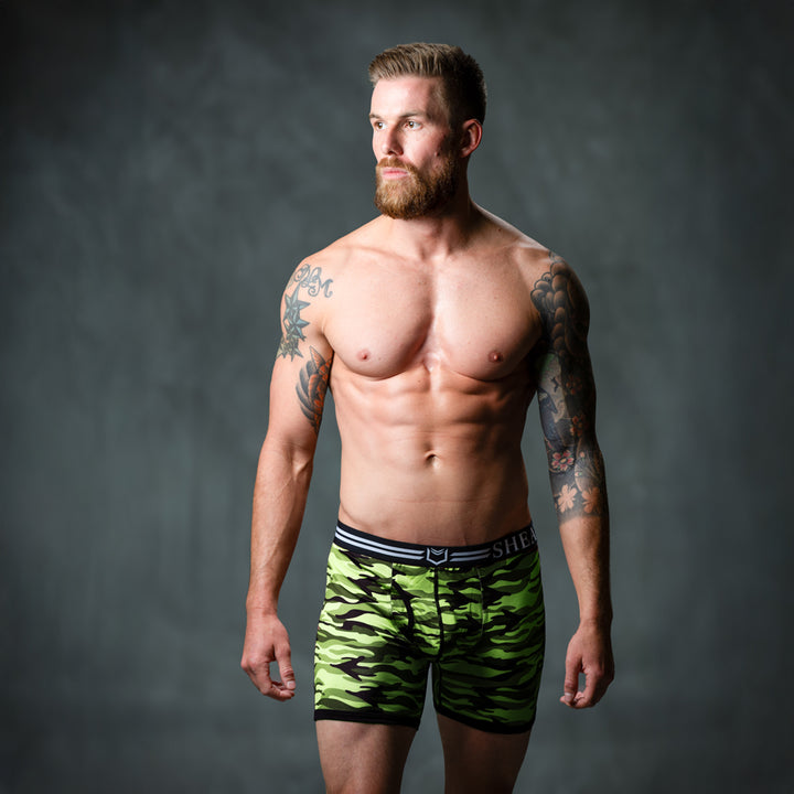 Male model in front of studio backdrop wearing SHEATH Green camo men&